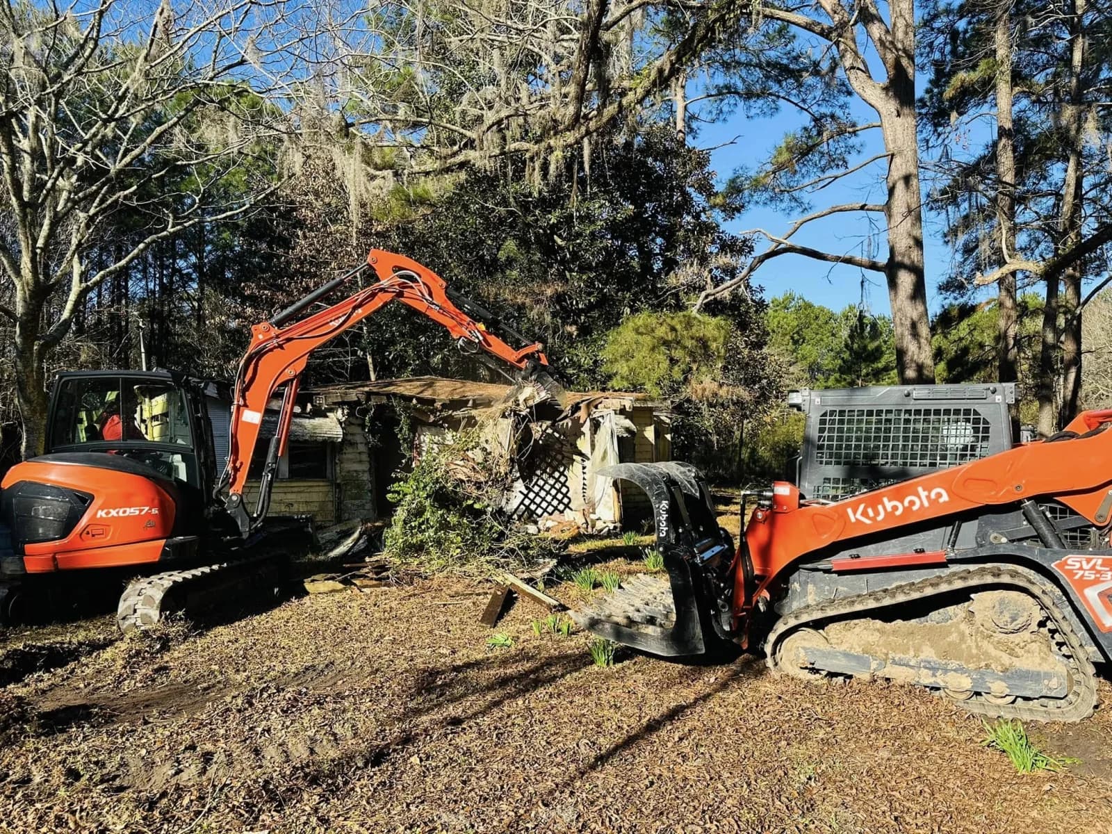Excavator and compact track loader performing residential demolition